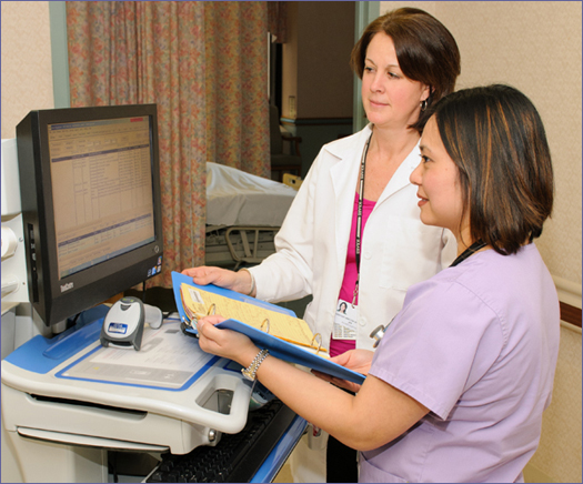 Mary Pat Boehler, RPh, and Bernadette Klabonski, BSN, RNC, verify a patient’s medication profile, reviewing the paper medical record and the online medication administration record.